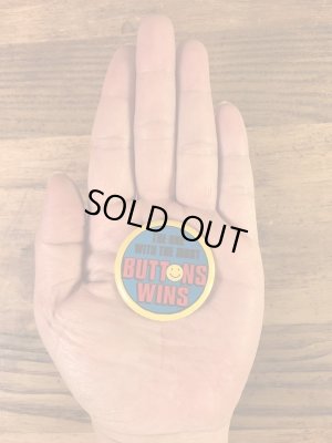 “The One With The Most Buttons Wins”と書かれたスマイルの80年代ビンテージ缶バッジ