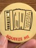 アコーディオンとSqueeze Meのメッセージが描かれたビンテージ缶バッジ