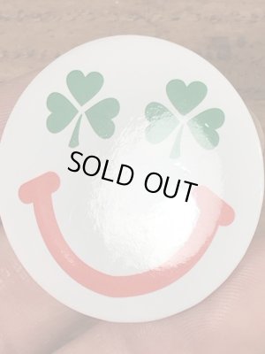 目がクローバーになったスマイルフェイスのヴィンテージ缶バッチ