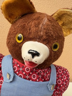 オーバーオールを着たオールドテディベアのぬいぐるみ