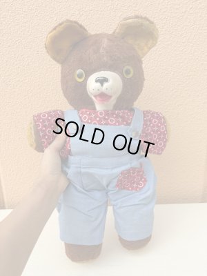 オーバーオールを着たオールドテディベアのぬいぐるみ