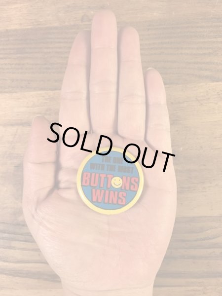 “The One With The Most Buttons Wins”と書かれたスマイルの80年代ビンテージ缶バッジ