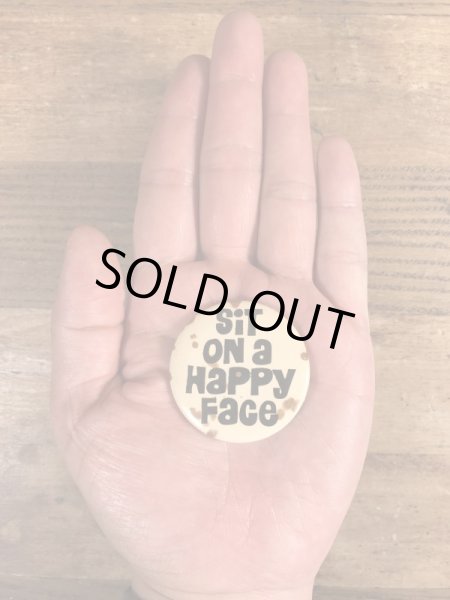 80年代頃のSit On A Happy Faceのメッセージが書かれたビンテージの缶バッジ