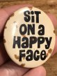 80年代頃のSit On A Happy Faceのメッセージが書かれたビンテージの缶バッジ