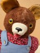 オーバーオールを着たオールドテディベアのぬいぐるみ