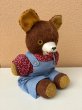 オーバーオールを着たオールドテディベアのぬいぐるみ